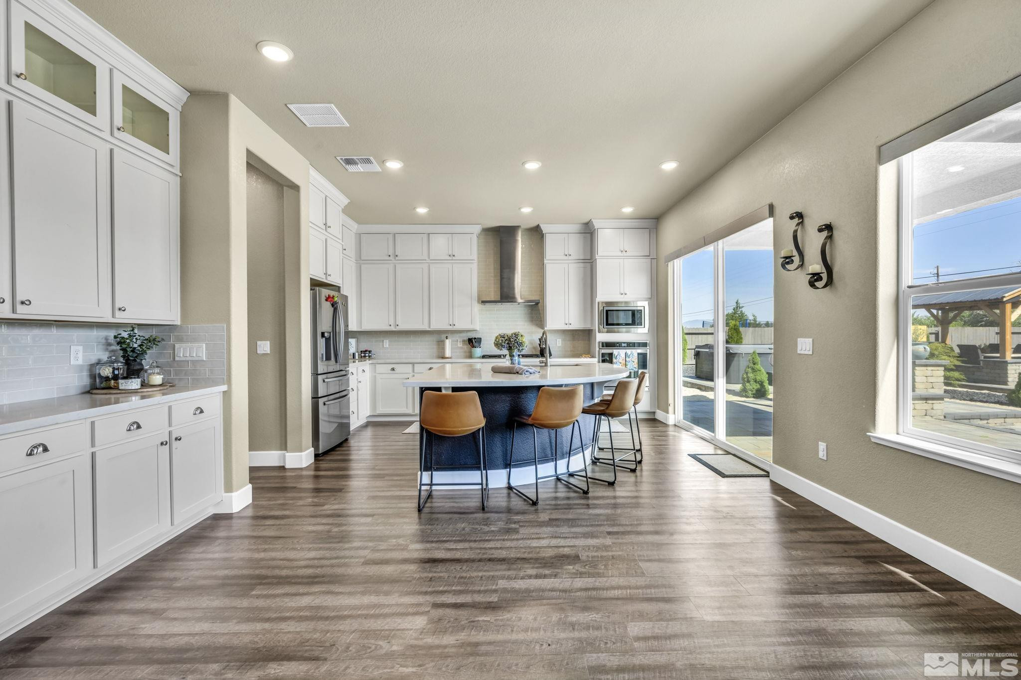 1237 Crawford Crk Drive Reno, NV 89521 - Photo 2 of 39 a kitchen with stainless steel appliances granite countertop a refrigerator a stove top oven and a dining table with wooden floor