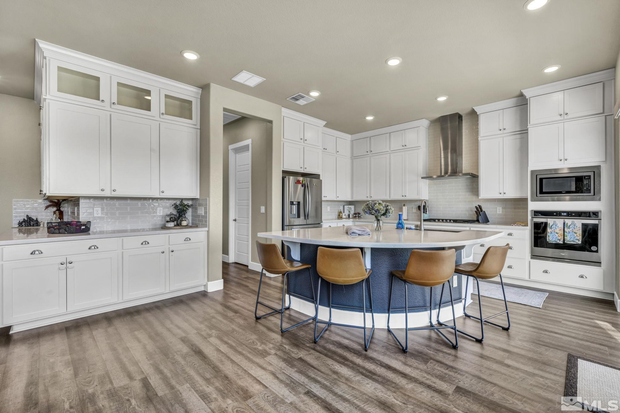 1237 Crawford Crk Drive Reno, NV 89521 - Photo 4 of 39 a kitchen with stainless steel appliances granite countertop a white cabinets and wooden floor