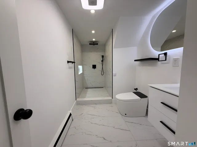 a bathroom with a toilet and a shower