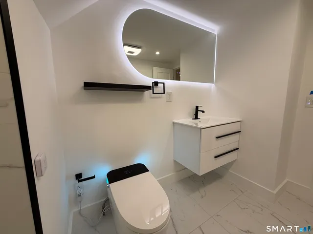 a bathroom with a sink mirror vanity and toilet