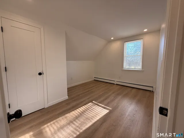 a view of an empty room and wooden floor