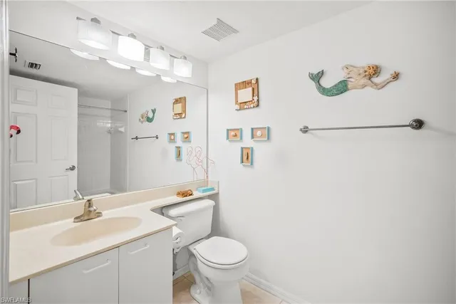 a bathroom with a sink vanity mirror and toilet