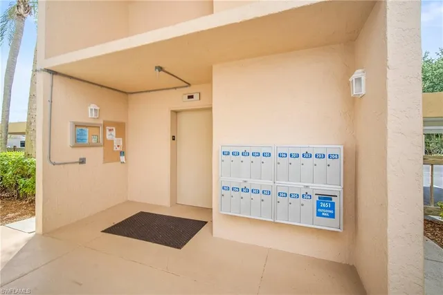 a view of a hallway with an empty room and chandelier fan