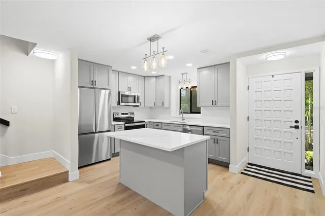 a kitchen with refrigerator cabinets and wooden floor