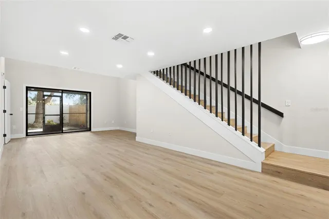 a view of an empty room with wooden floor