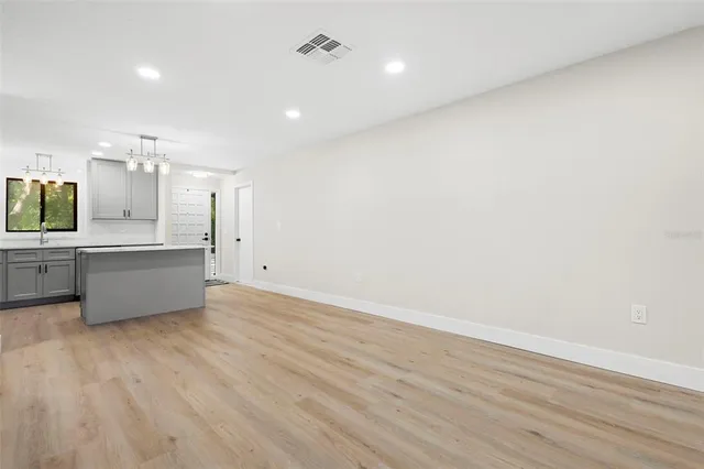 a large kitchen with a wooden floor and stainless steel appliances
