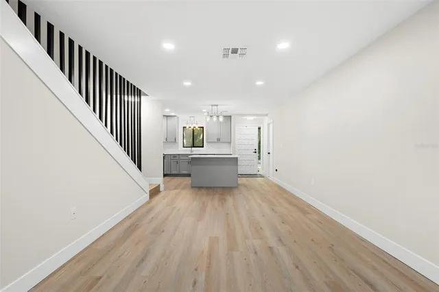 a view of a hallway with wooden floor and staircase