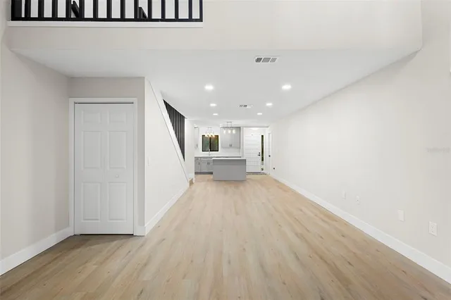 a view of a hallway with wooden floor and staircase