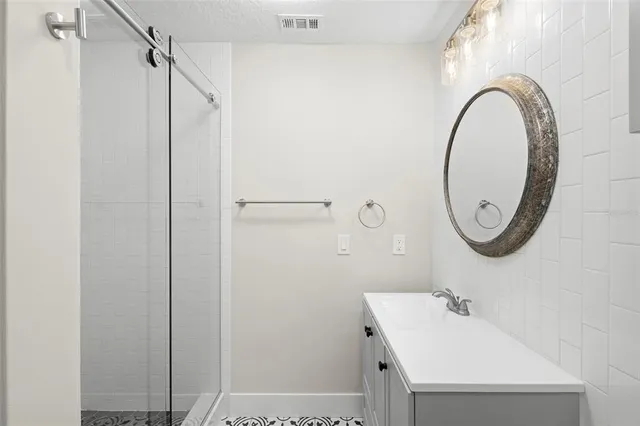 a bathroom with a sink a mirror and a shower