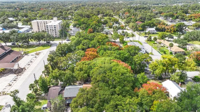 an aerial view of residential houses with outdoor space and trees all around