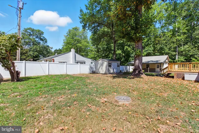 a backyard of a house with table and chairs a barbeque with wooden fence