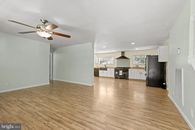 a view of kitchen with refrigerator cabinet and wooden floor