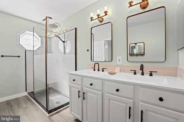 a bathroom with a double vanity sink mirror and shower