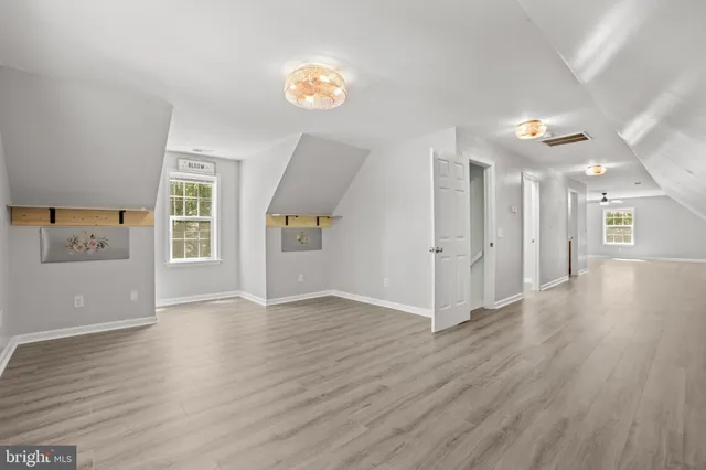 a view of a hallway with wooden floor and a window