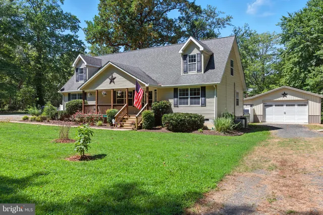 a front view of a house with a yard and green space