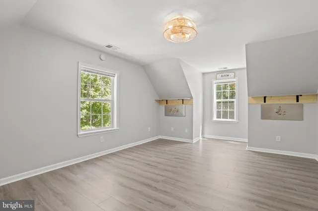 an empty room with wooden floor and window