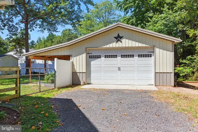 a view of small house with a yard and garage