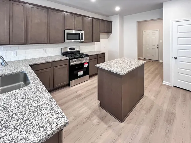 a kitchen with a stove a sink and a microwave