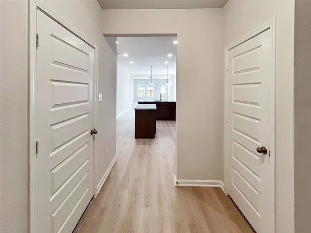 a view of a hallway with wooden floor and staircase