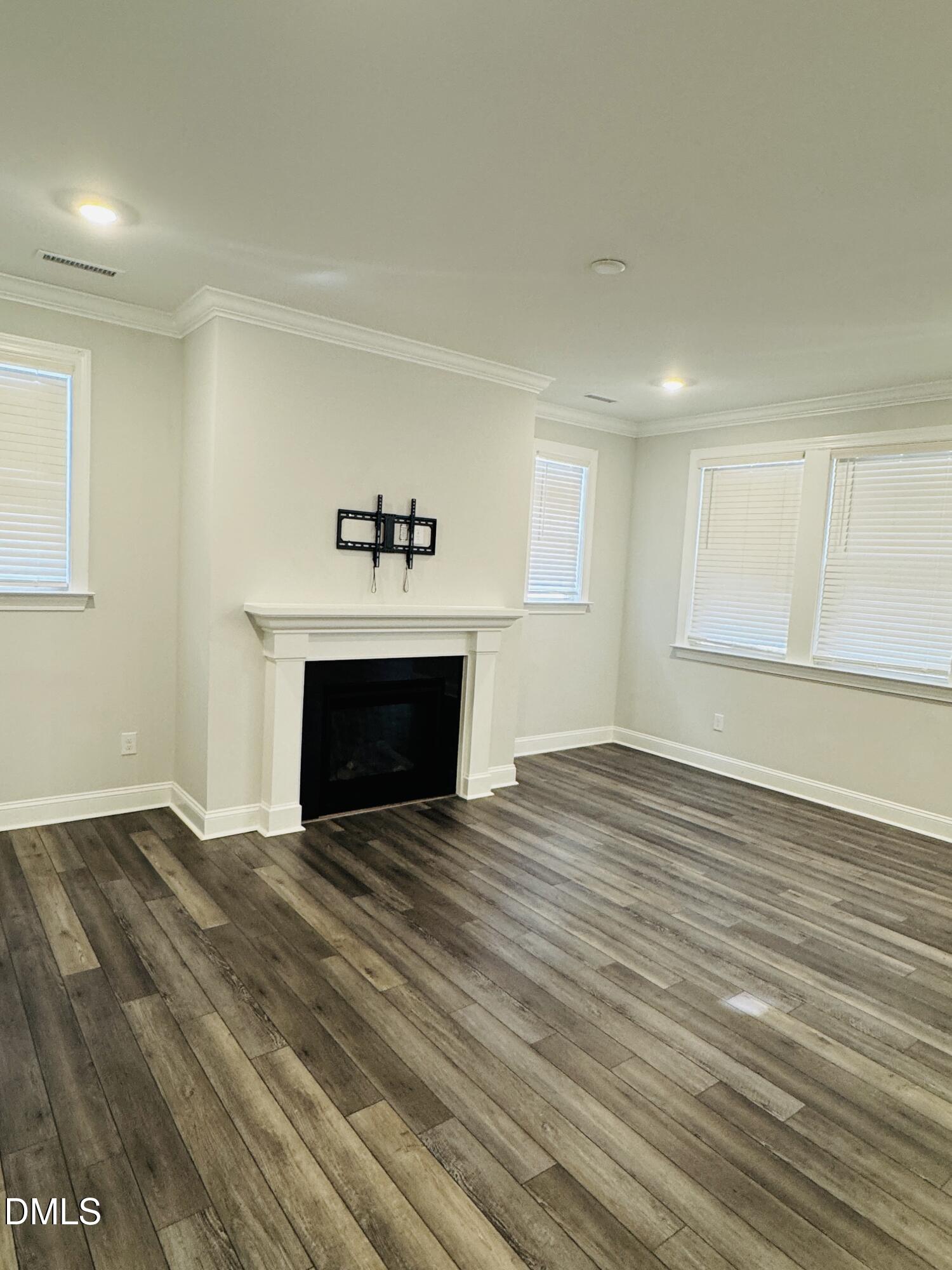 292 Edge Of Auburn Boulevard Raleigh, NC 27610 - Photo 13 of 38 a view of empty room with wooden floor and fireplace