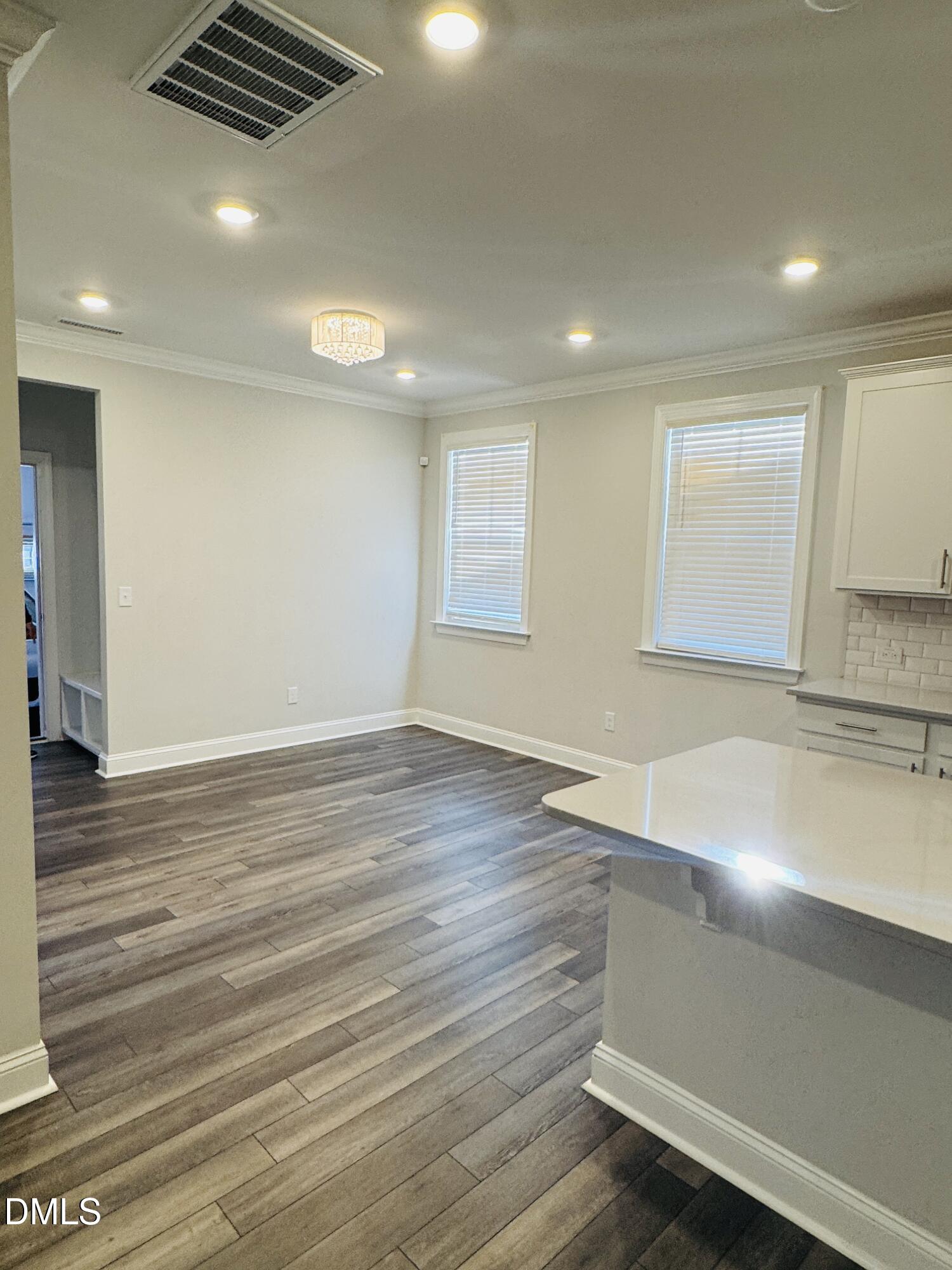 292 Edge Of Auburn Boulevard Raleigh, NC 27610 - Photo 16 of 38 an empty room with wooden floor and windows