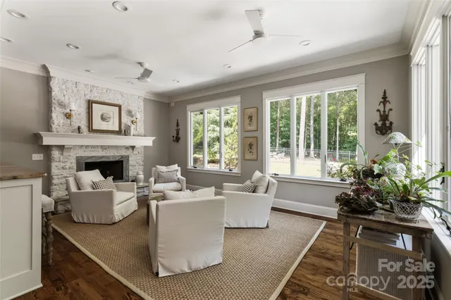 a living room with furniture large window and flower plants