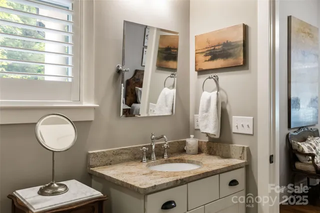 a bathroom with a granite countertop sink and a mirror