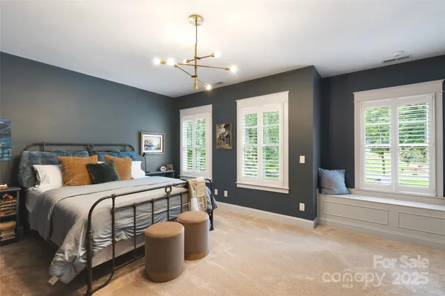 a bedroom with a large bed and windows