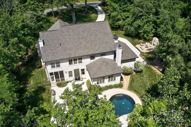 an aerial view of a house with swimming pool and garden