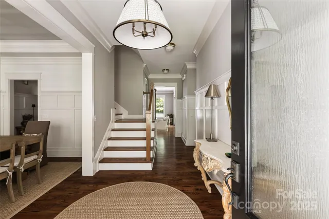 a view of a hallway with wooden floor and dining room