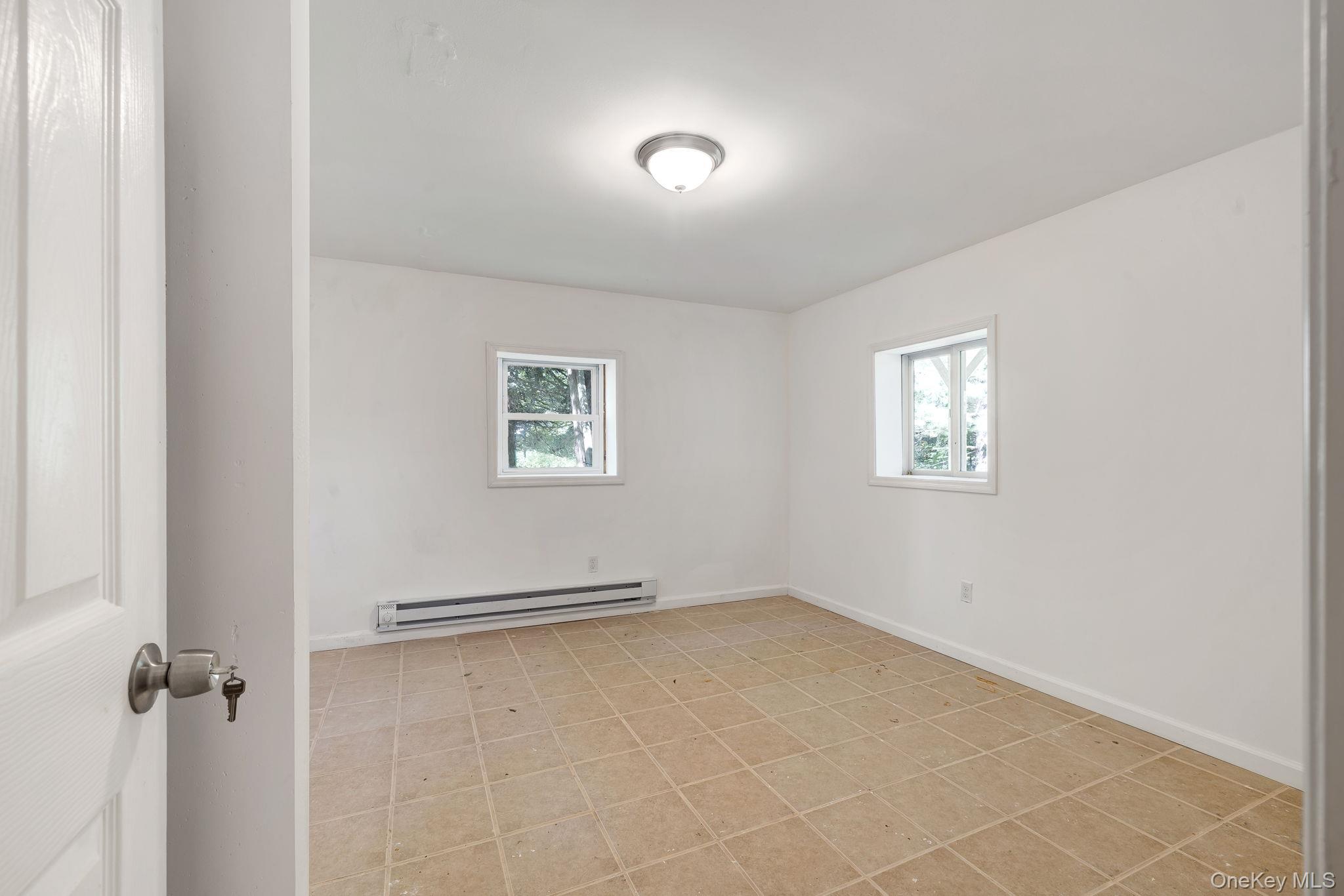 1463 Briscoe Road Swan Lake, NY 12783 - Photo 12 of 21 Unfurnished room with baseboard heating and baseboards