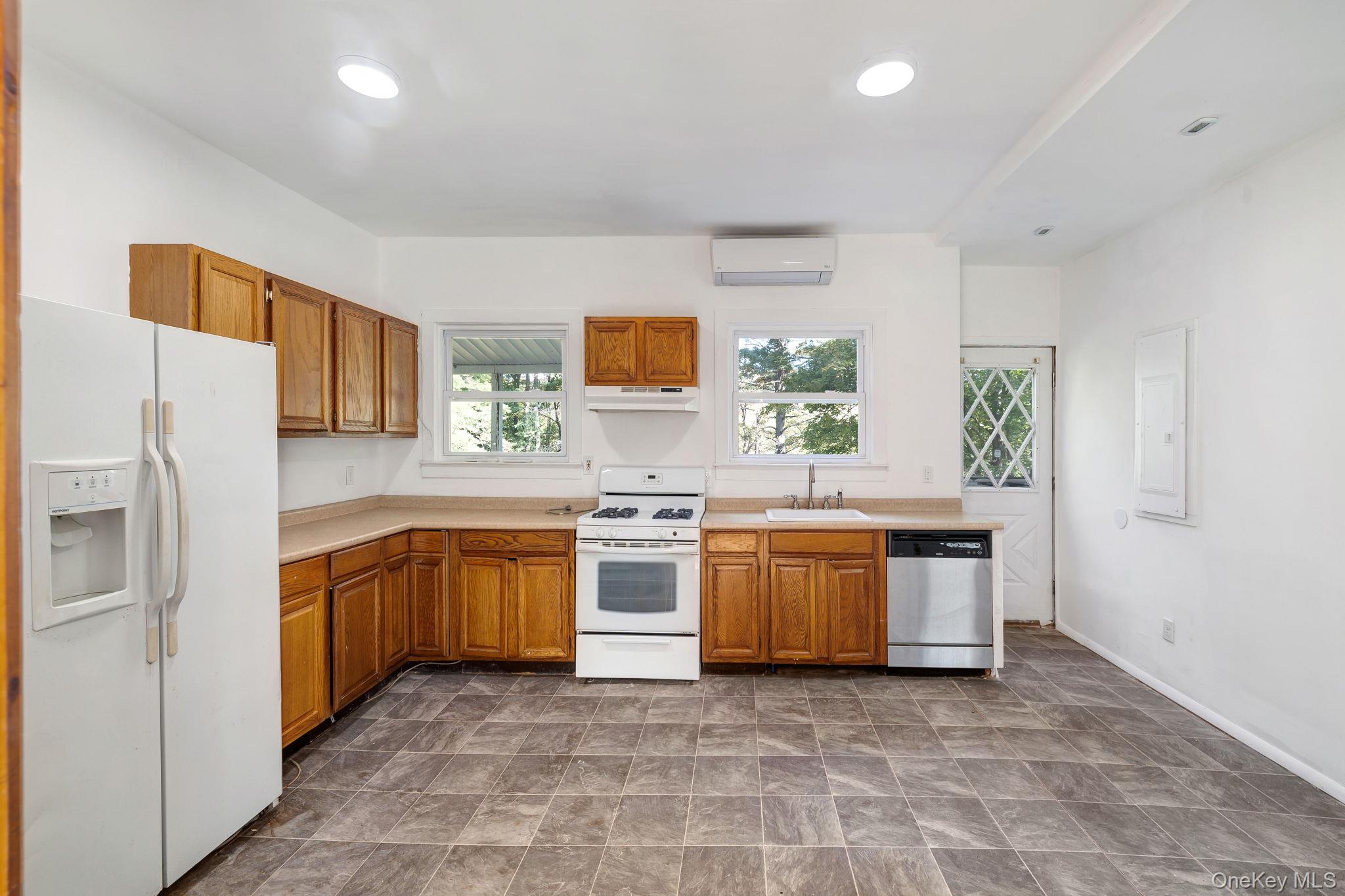 1463 Briscoe Road Swan Lake, NY 12783 - Photo 3 of 21 Kitchen with white appliances, wood finish cabinets, stone finish flooring, and light countertops