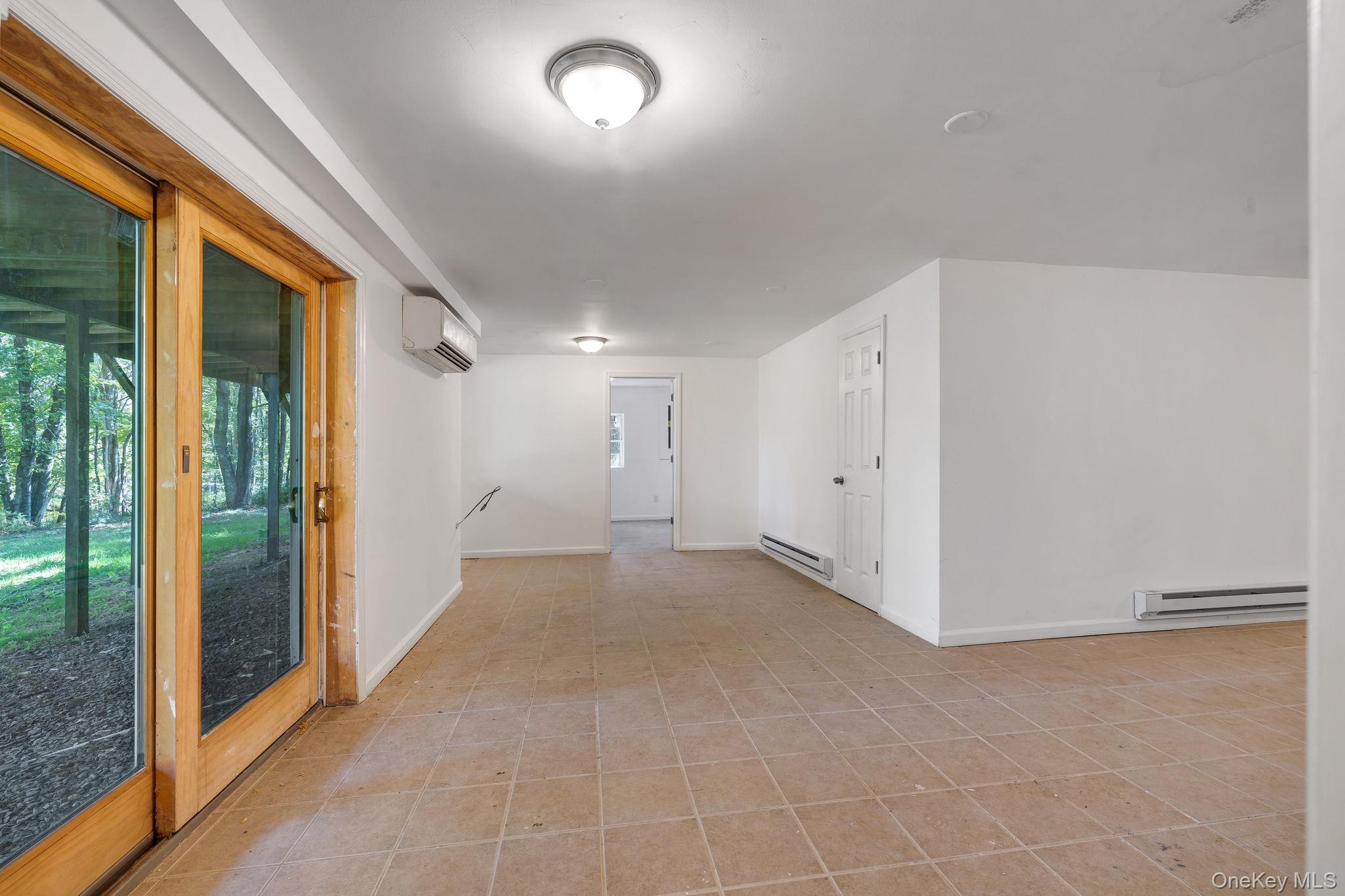 1463 Briscoe Road Swan Lake, NY 12783 - Photo 7 of 21 Unfurnished room with a baseboard heating unit, a baseboard radiator, and light tile patterned floors
