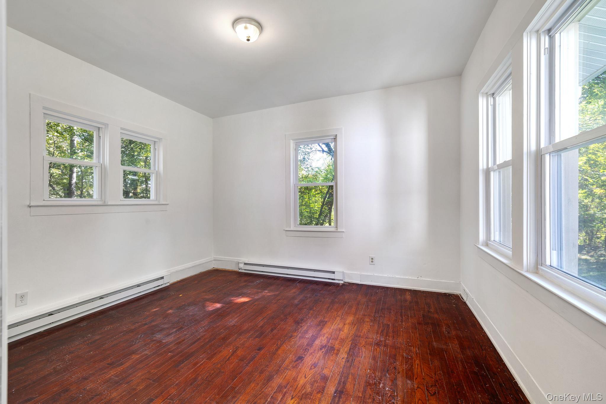 1463 Briscoe Road Swan Lake, NY 12783 - Photo 8 of 21 Spare room with a baseboard heating unit and dark wood finished floors