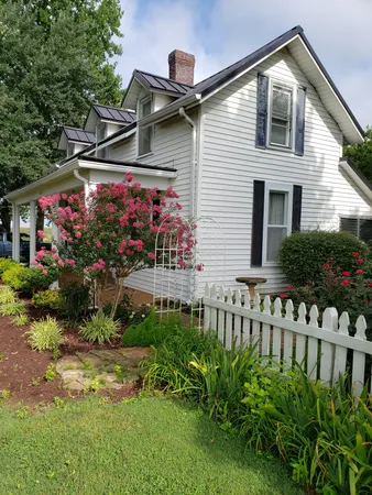 a front view of house and yard with beautiful flowers and green space