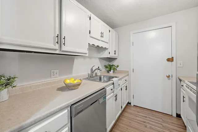 a kitchen with stainless steel appliances granite countertop a sink and a white wooden cabinets
