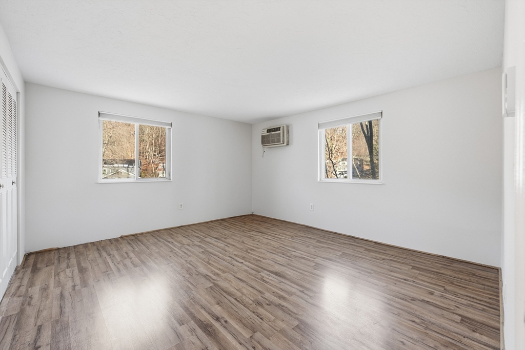 10 Mill Street, Unit Q Maynard, MA 01754 - Photo 17 of 31 a view of an empty room with wooden floor and a window