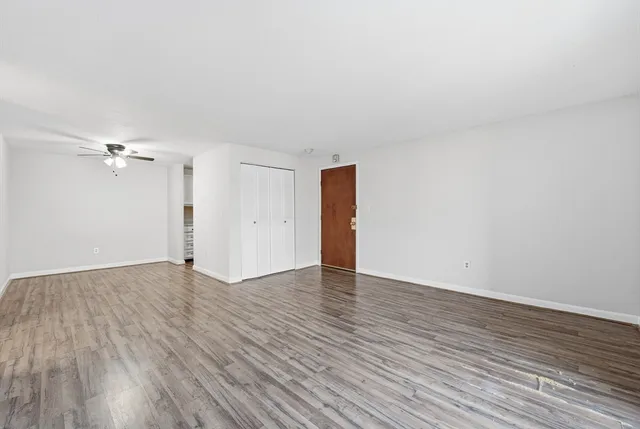 a view of empty room with wooden floor