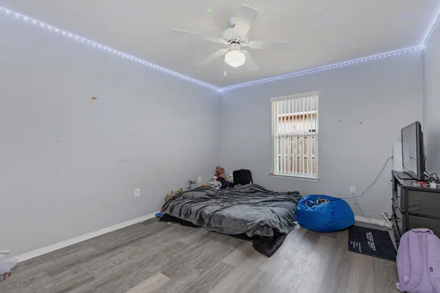 a bedroom with a bed a window and a chandelier