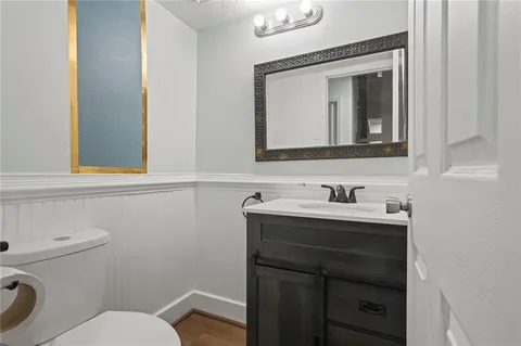 a bathroom with a toilet sink vanity and mirror