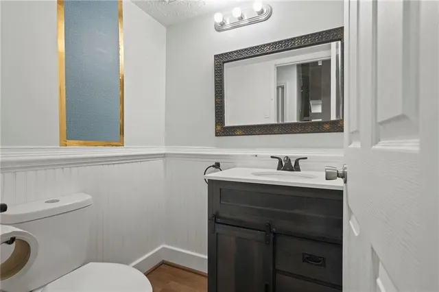a bathroom with a toilet sink vanity and mirror