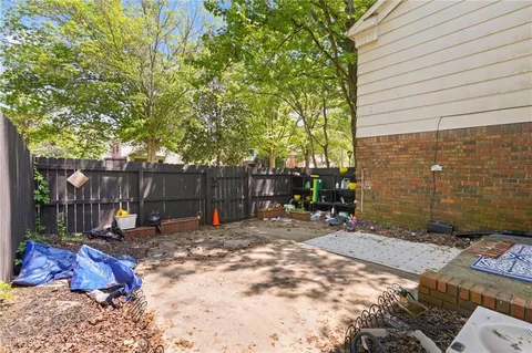 a view of backyard with wooden fence and a large tree