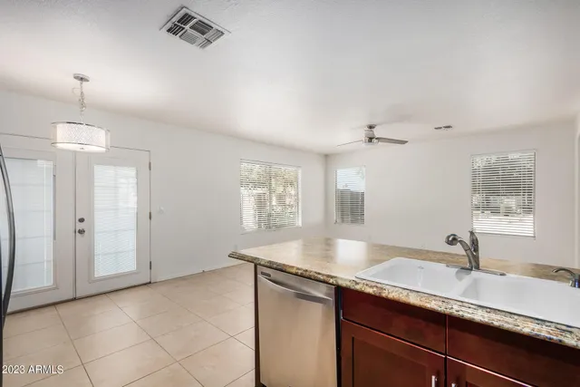 a view of a refrigerator a sink and cabinets