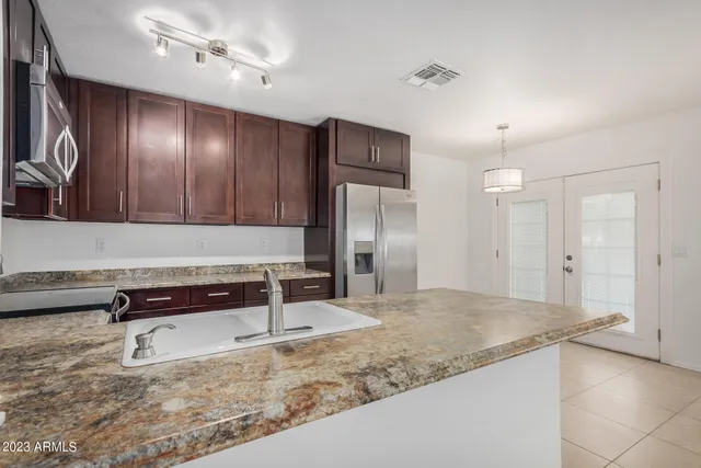 a view of a refrigerator in kitchen and white cabinets