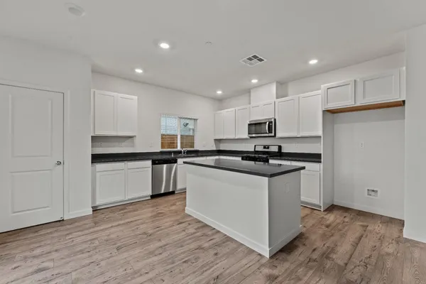 a kitchen with stainless steel appliances granite countertop a refrigerator and a stove top oven