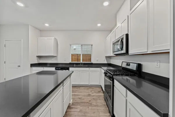 a kitchen with a sink stove top oven and cabinets