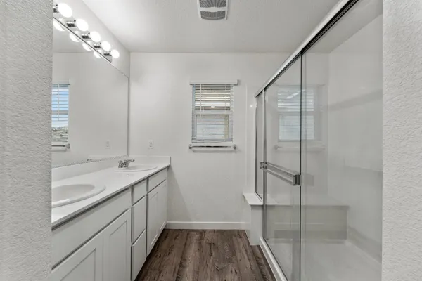 a bathroom with a granite countertop sink a toilet and shower