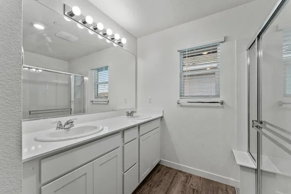 a bathroom with a granite countertop sink a mirror and a shower