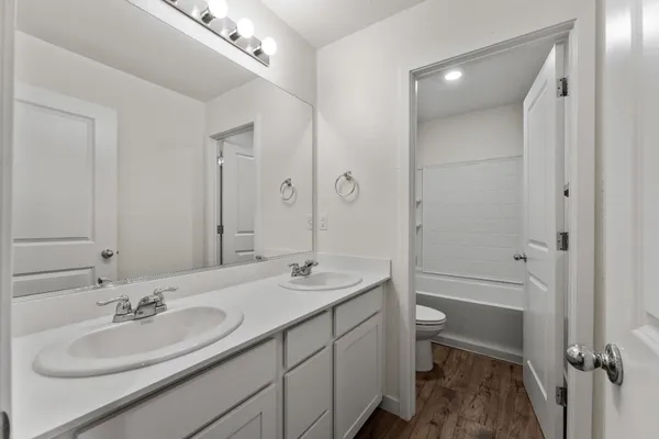 a bathroom with a sink double vanity granite tub and a mirror