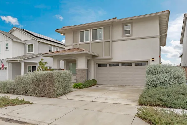 a front view of a house with a yard and garage
